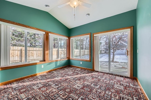 unfurnished sunroom featuring ceiling fan, a healthy amount of sunlight, and vaulted ceiling