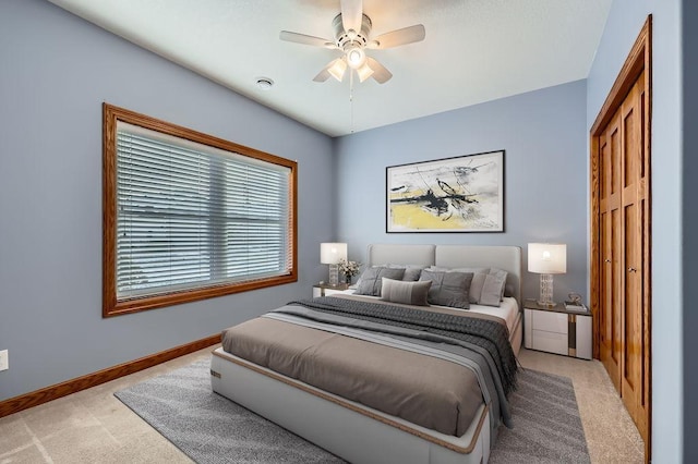 carpeted bedroom with ceiling fan and a closet