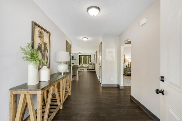 corridor featuring a textured ceiling and dark hardwood / wood-style flooring