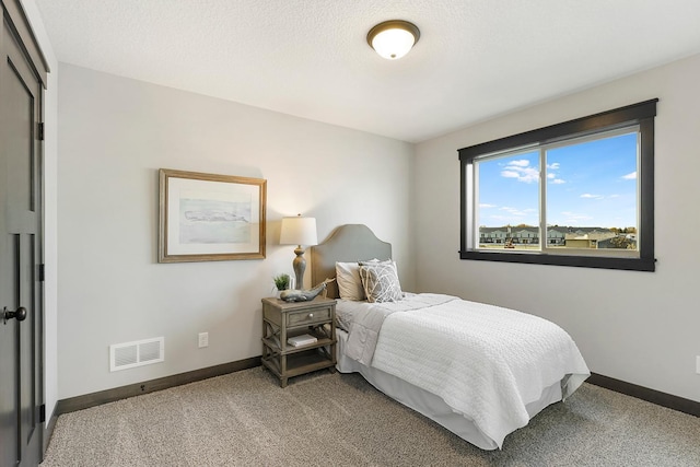 bedroom with a textured ceiling and carpet floors