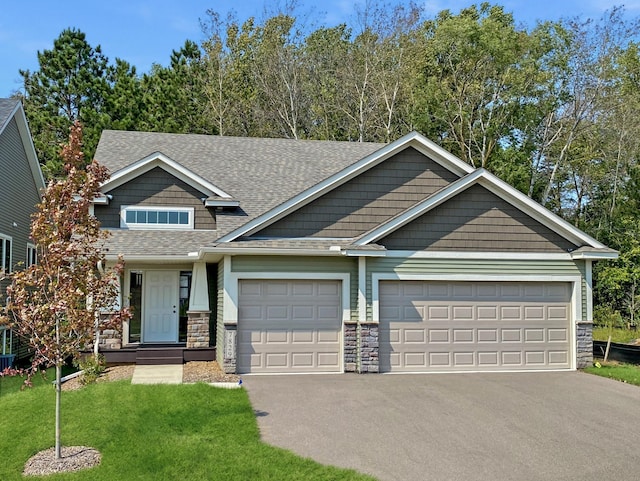 craftsman house featuring a garage and a front lawn