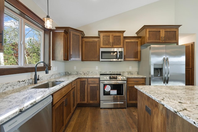 kitchen featuring sink, hanging light fixtures, dark hardwood / wood-style floors, vaulted ceiling, and appliances with stainless steel finishes