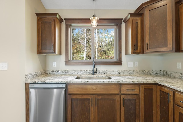 kitchen with dishwasher, decorative light fixtures, light stone counters, and sink