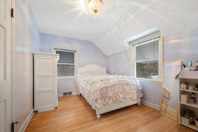 bedroom with lofted ceiling and light wood-type flooring