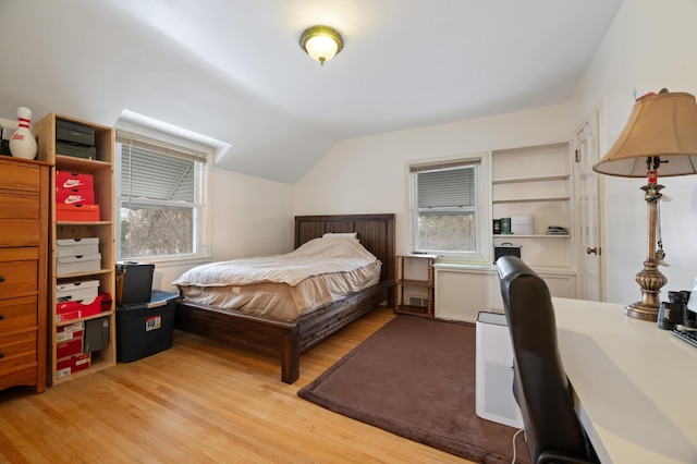 bedroom with light hardwood / wood-style floors and lofted ceiling