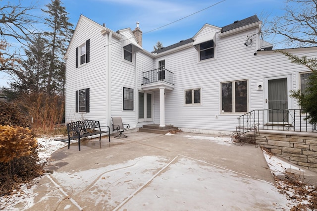 snow covered property featuring a balcony and a patio