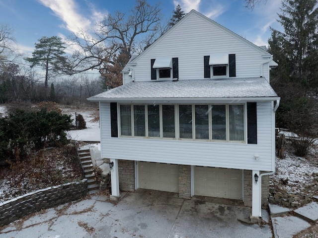 view of snow covered exterior with a garage