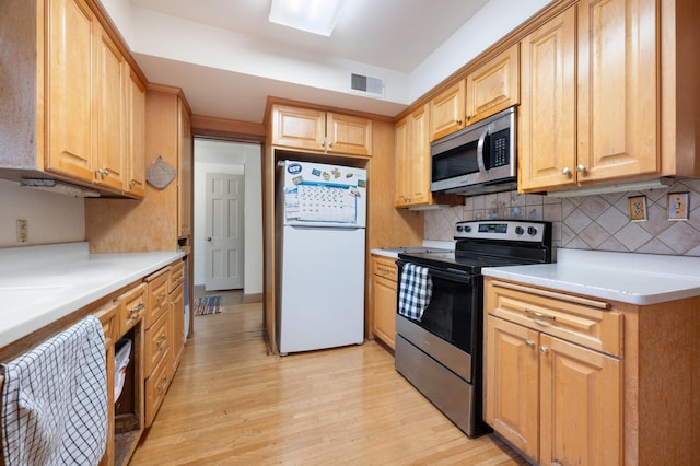 kitchen featuring tasteful backsplash, light wood-type flooring, and appliances with stainless steel finishes