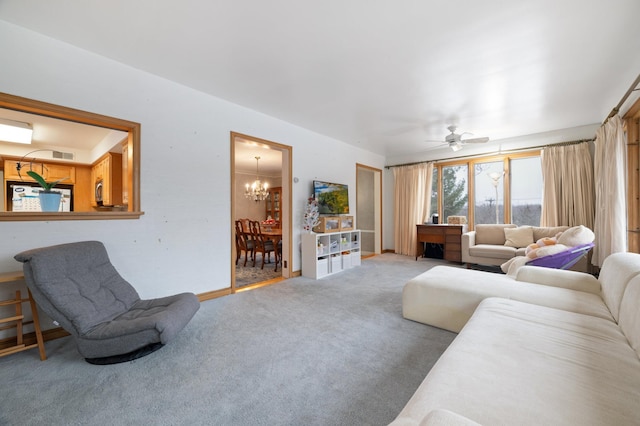 carpeted living room with ceiling fan with notable chandelier