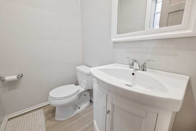 bathroom featuring hardwood / wood-style floors, vanity, and toilet