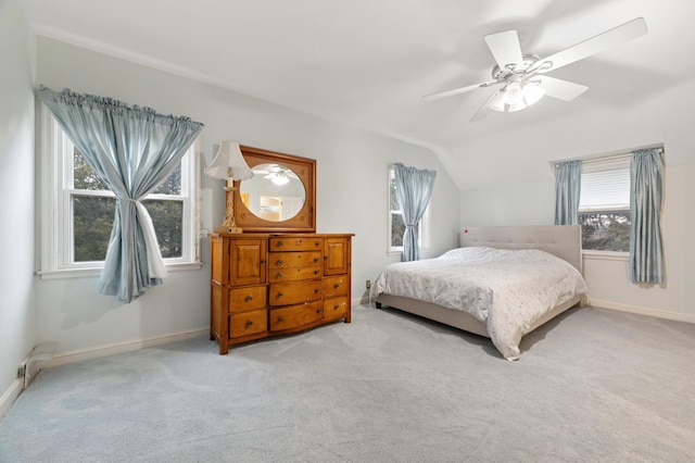 bedroom featuring multiple windows, ceiling fan, light carpet, and vaulted ceiling