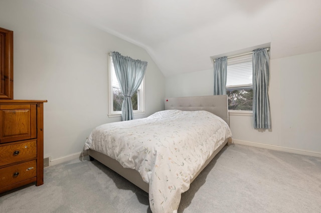 bedroom featuring light colored carpet and lofted ceiling