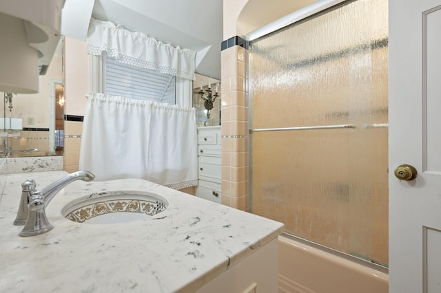 bathroom with vanity and combined bath / shower with glass door