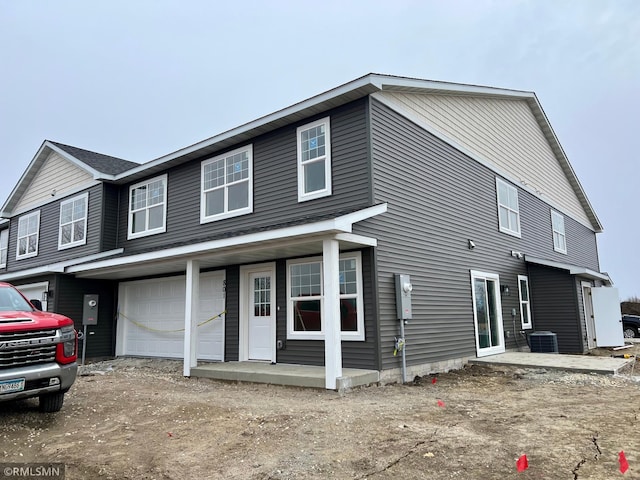 view of front of home with a garage and central AC