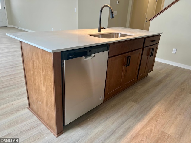 kitchen with stainless steel dishwasher, a kitchen island with sink, sink, and light hardwood / wood-style floors