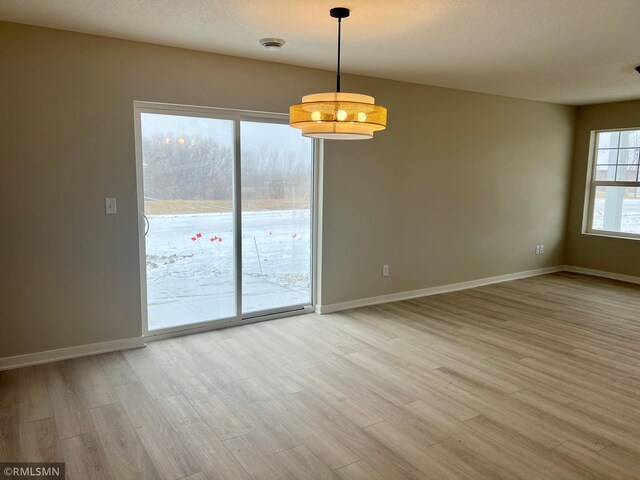 unfurnished room featuring a wealth of natural light and hardwood / wood-style flooring