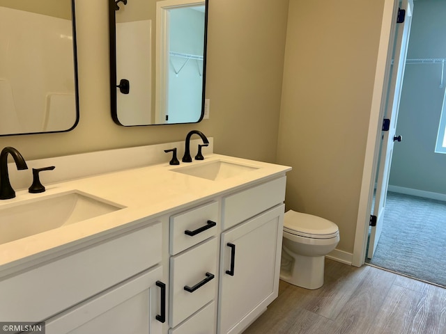 bathroom with hardwood / wood-style flooring, toilet, and vanity