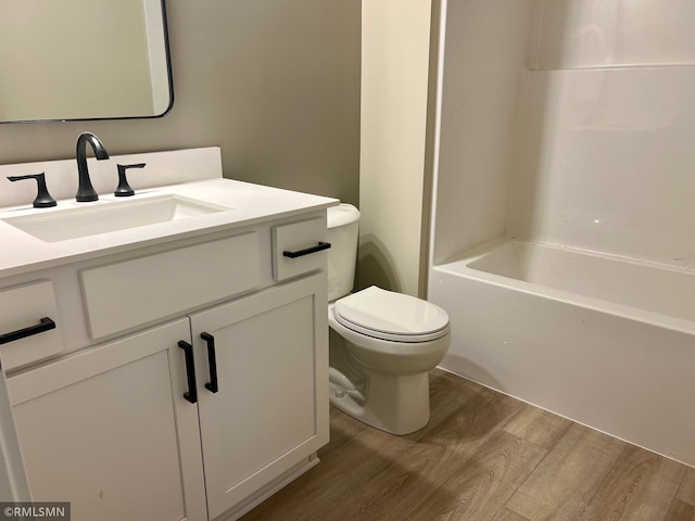 bathroom with toilet, vanity, and hardwood / wood-style flooring