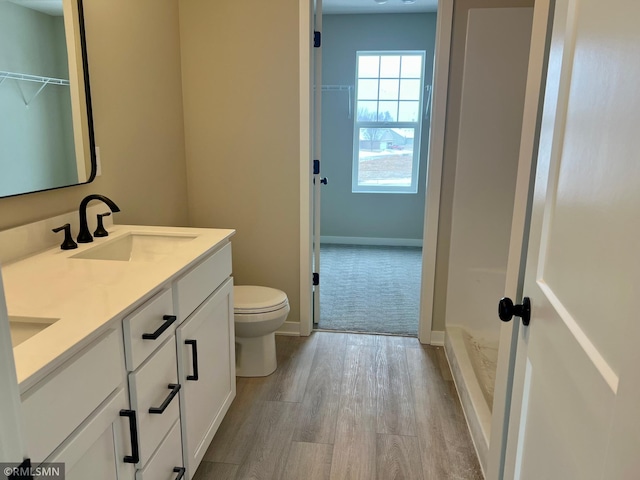 bathroom with toilet, vanity, and hardwood / wood-style floors