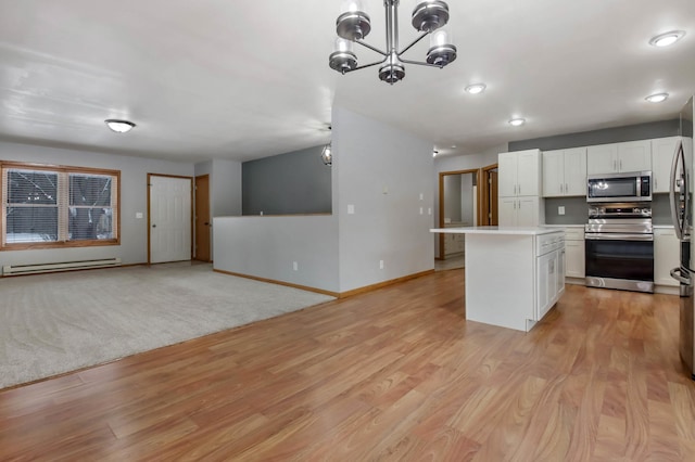 kitchen with white cabinetry, a baseboard radiator, appliances with stainless steel finishes, and decorative light fixtures