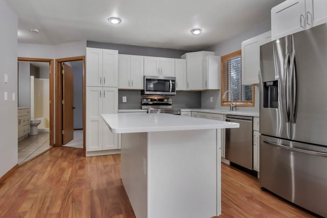 kitchen featuring a kitchen island, white cabinetry, and appliances with stainless steel finishes