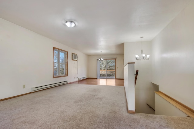 unfurnished room with a wall unit AC, carpet floors, an inviting chandelier, and baseboard heating