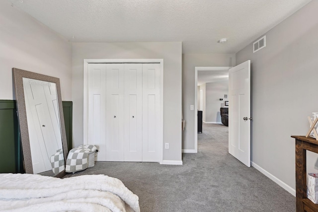 carpeted bedroom featuring a closet and a textured ceiling