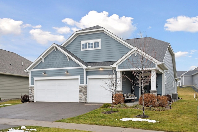 craftsman house featuring central AC, a front lawn, and a garage