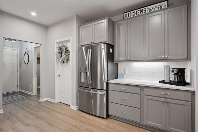 kitchen with backsplash, gray cabinets, and stainless steel refrigerator with ice dispenser