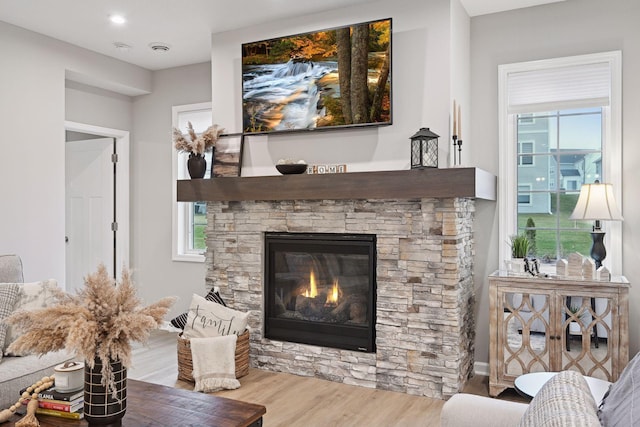 living room with a wealth of natural light, a fireplace, and light wood-type flooring