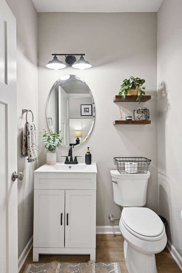 bathroom with hardwood / wood-style flooring, vanity, and toilet