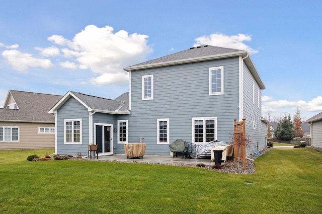 back of house with a yard and a patio