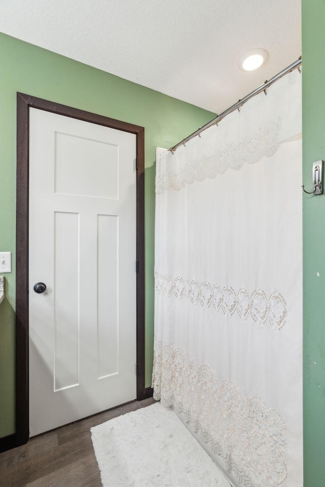 bathroom with hardwood / wood-style floors and a textured ceiling