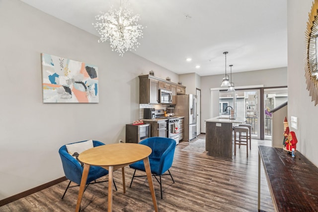 dining area featuring a notable chandelier, dark hardwood / wood-style flooring, and sink