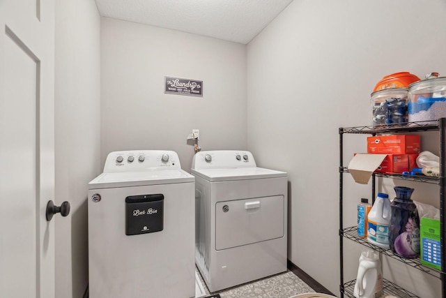 laundry area featuring washer and clothes dryer and a textured ceiling