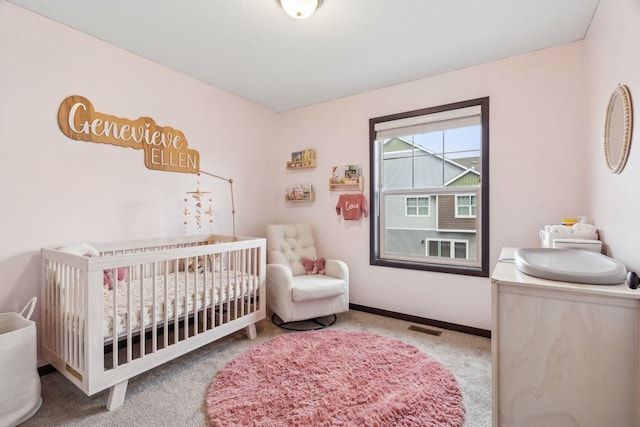 carpeted bedroom with a nursery area