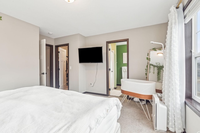 bedroom featuring light carpet and ensuite bathroom