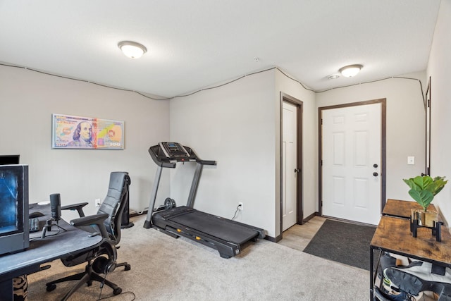 workout area featuring light colored carpet and a textured ceiling