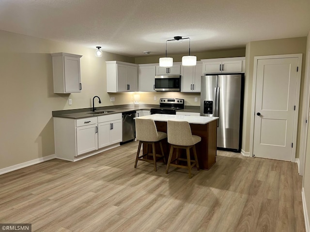 805 Tomahawk Ct, Madison Lake, MN 56063 - kitchen with a kitchen bar, a center island, a sink, light wood finished floors, and appliances with stainless steel finishes