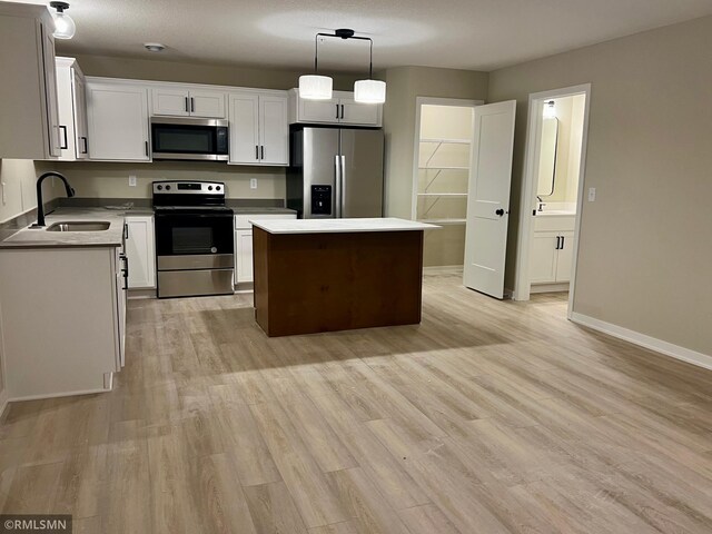805 Tomahawk Ct, Madison Lake, MN 56063 - kitchen featuring a sink, stainless steel appliances, a center island, and light wood-type flooring