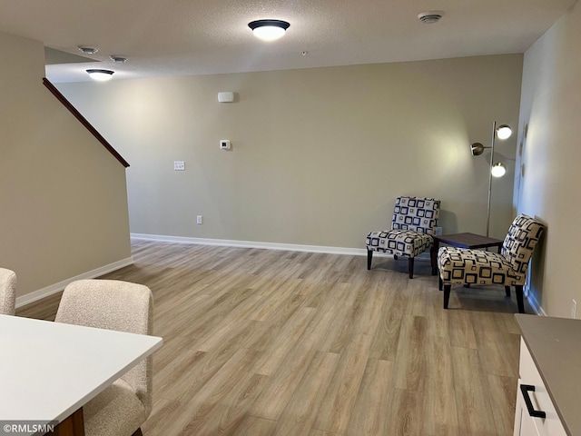 805 Tomahawk Ct, Madison Lake, MN 56063 - sitting room with baseboards, a textured ceiling, and light wood-style flooring