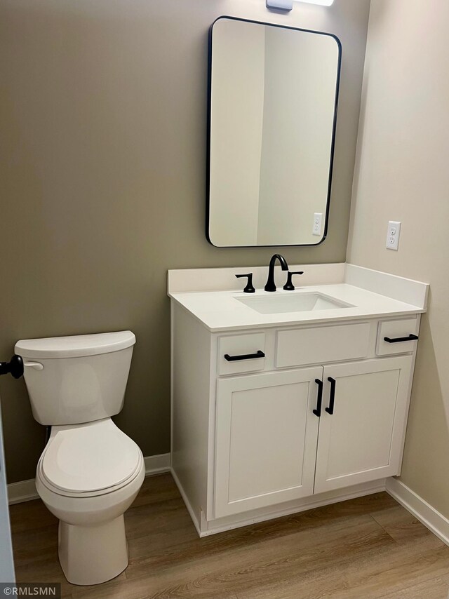 805 Tomahawk Ct, Madison Lake, MN 56063 - bathroom with toilet, vanity, baseboards, and wood finished floors