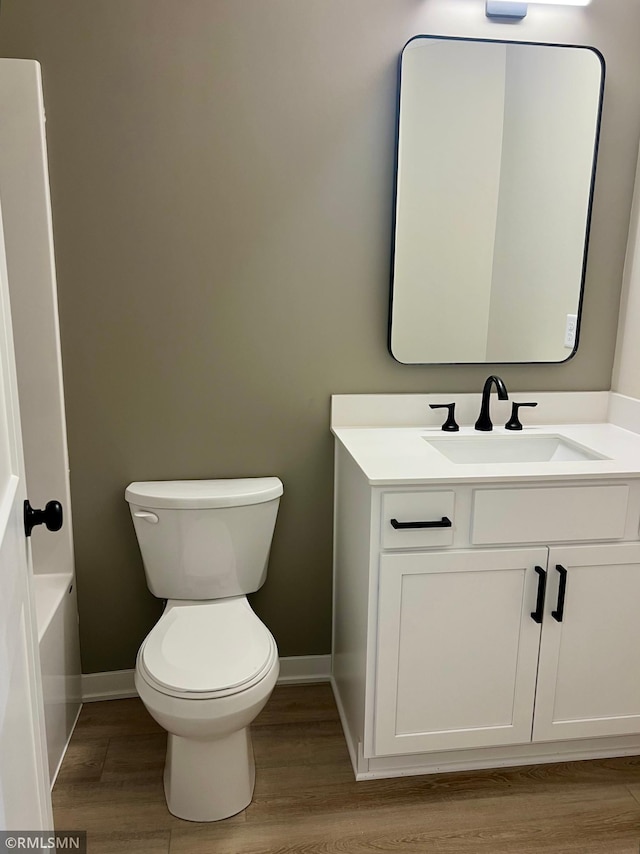 805 Tomahawk Ct, Madison Lake, MN 56063 - bathroom featuring baseboards, wood finished floors, toilet, and vanity
