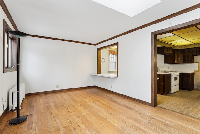 unfurnished living room featuring crown molding, radiator, and light hardwood / wood-style floors