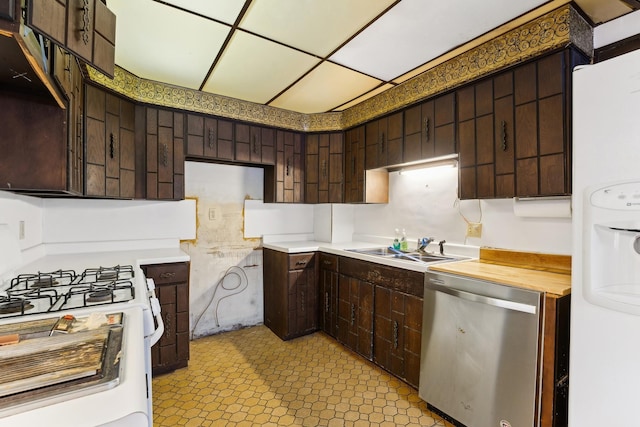 kitchen featuring a paneled ceiling, butcher block counters, sink, dark brown cabinets, and white appliances