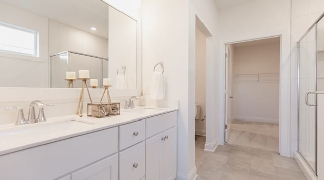 bathroom featuring tile patterned floors, vanity, an enclosed shower, and toilet