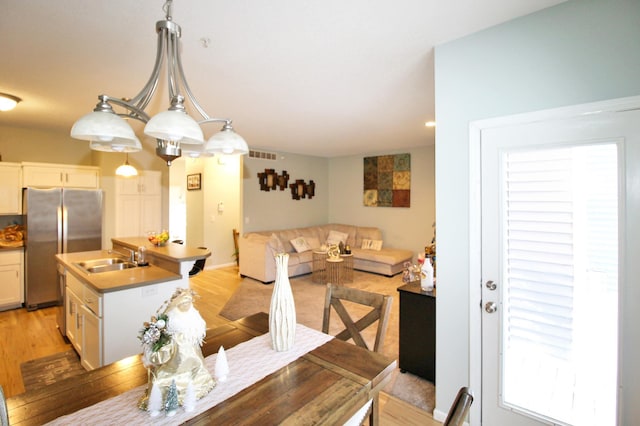 dining area with plenty of natural light, sink, and light hardwood / wood-style flooring