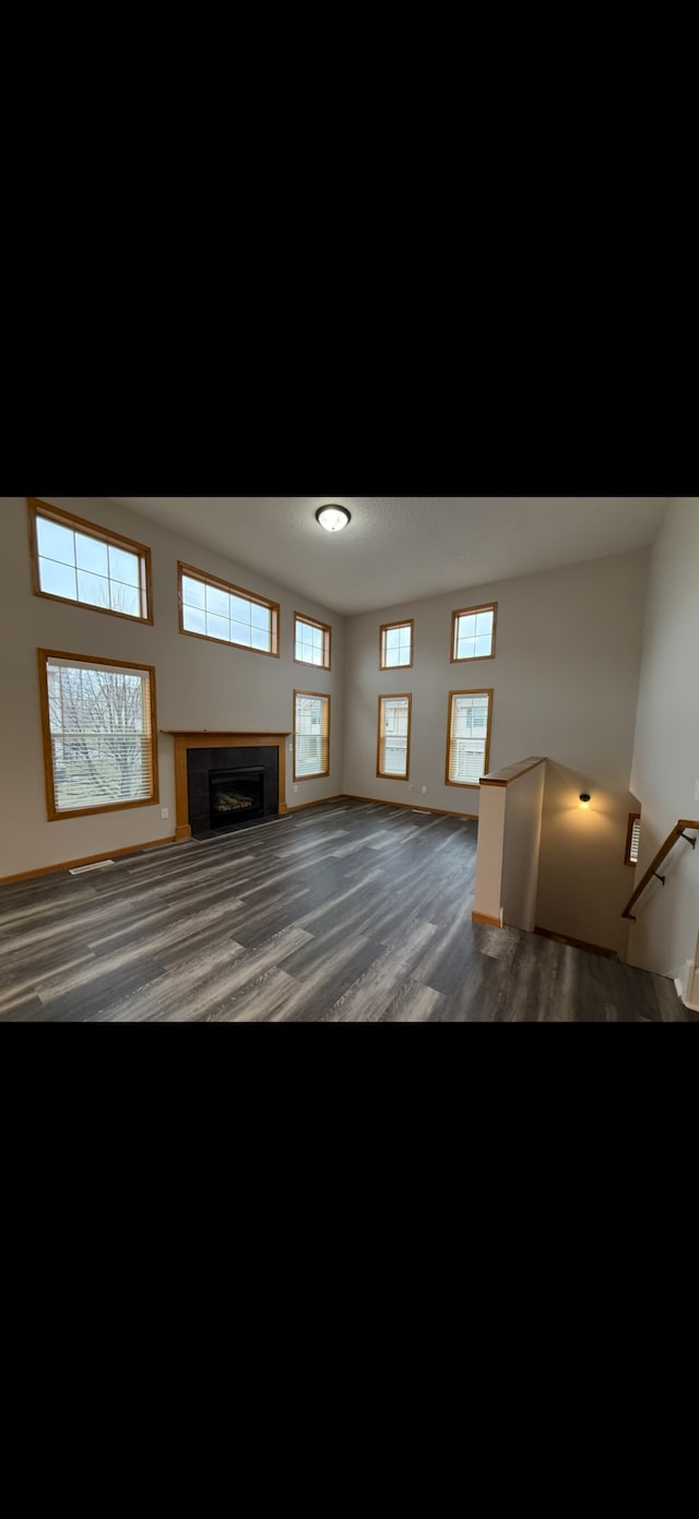 unfurnished living room with plenty of natural light and dark hardwood / wood-style flooring