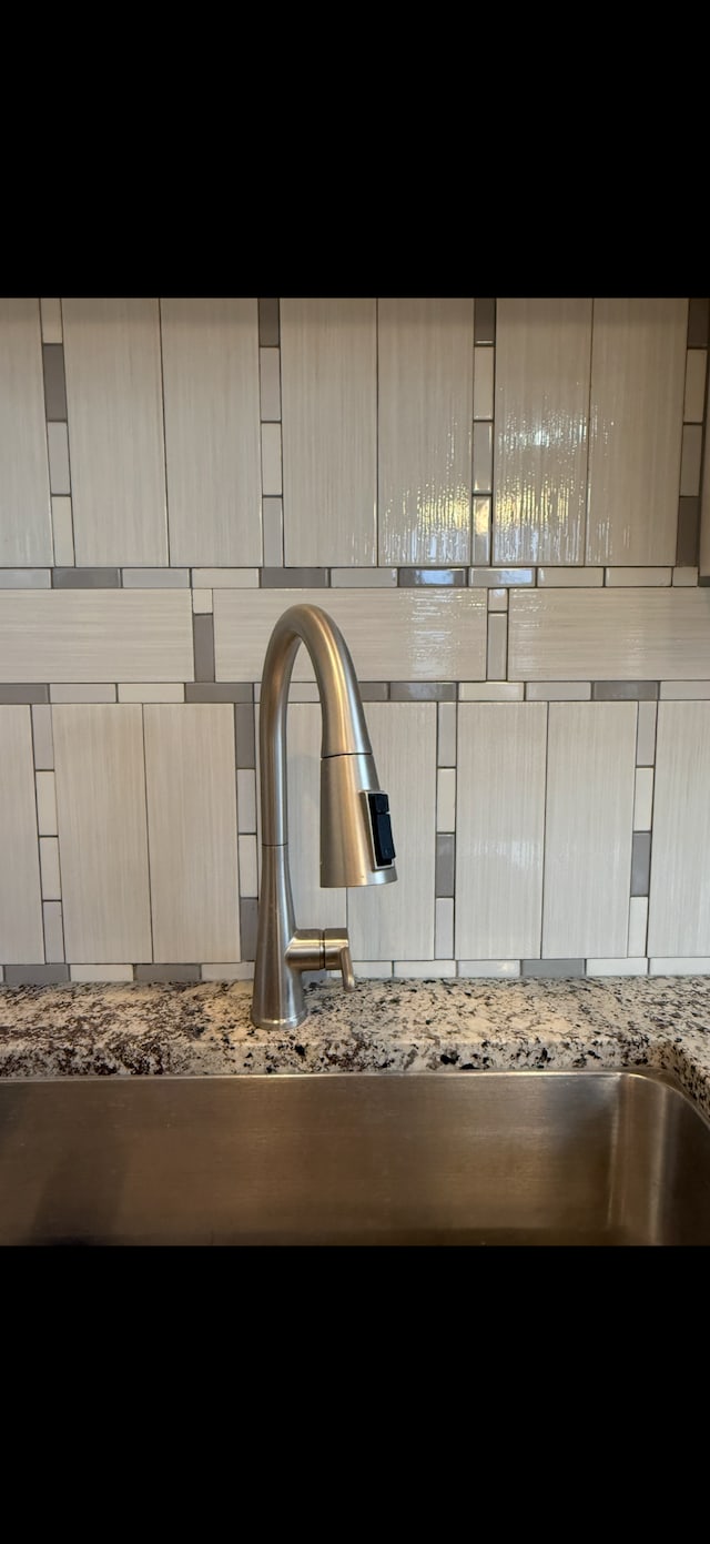 details featuring light brown cabinets, stone countertops, and sink