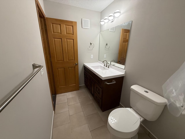 bathroom featuring toilet, a textured ceiling, vanity, and tile patterned floors